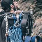 Person with climbing gear including ropes and harnesses on a Tough Hook Hanger against a rocky background